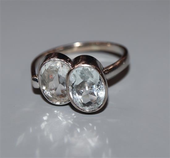 A French 18ct white metal and twin stone oval cut aquamarine dress ring, size N.